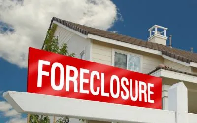 Foreclosure for sale sign in front of a house